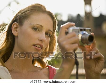Woman taking a photograph outdoors View Large Photo Image Stock Image - Woman taking a photograph outdoors. Fotosearch