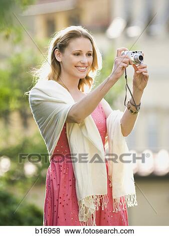 Woman taking a photograph outdoors View Large Photo Image Stock Photo - Woman taking a photograph outdoors. Fotosearch