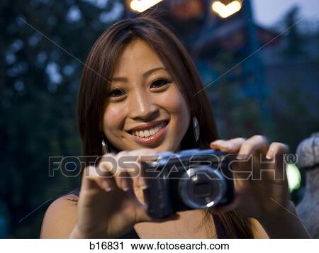 Woman taking a photograph smiling View Large Photo Image Stock Image - Woman taking a photograph smiling. Fotosearch