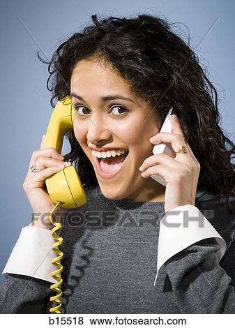 Woman talking on cell phone and retro telephone smiling View Large Photo Image Stock Photo - Woman talking on cell phone and retro telephone smiling. Fotosearch