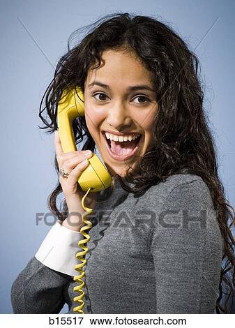 Woman talking on yellow telephone smiling View Large Photo Image Stock Photo - Woman talking on yellow telephone smiling. Fotosearch
