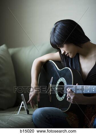 Woman tuning guitar with metronome View Large Photo Image Stock Image - Woman tuning guitar with metronome. Fotosearch