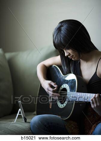 Woman tuning guitar with metronome View Large Photo Image Stock Image - Woman tuning guitar with metronome. Fotosearch