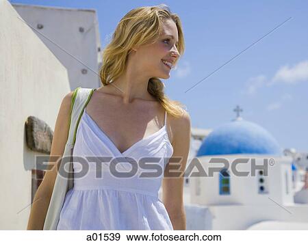 Woman walking and smiling outdoors with village church in background View Large Photo Image Stock Photo - Woman walking and smiling outdoors with village church in background. Fotosearch