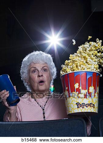 Woman watching film at movie theatre frightened View Large Photo Image Stock Photo - Woman watching film at movie theatre frightened. Fotosearch
