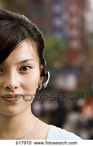 Woman with a cell phone earpiece. View Large Photo Image Stock Image - Woman with a cell phone earpiece.. Fotosearch