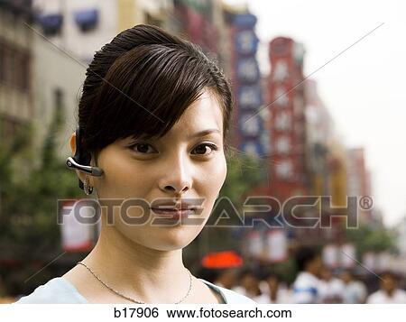 Woman with a cell phone earpiece. View Large Photo Image Stock Photograph - Woman with a cell phone earpiece.. Fotosearch