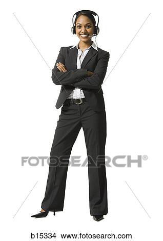 Woman with arms crossed and headset standing and smiling View Large Photo Image Picture - Woman with arms crossed and headset standing and smiling. Fotosearch