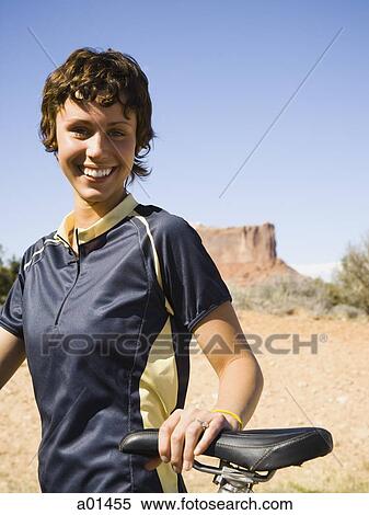 Woman with bicycle outdoors with red rock View Large Photo Image Stock Photography - Woman with bicycle outdoors with red rock. Fotosearch