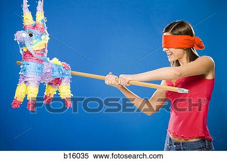 Woman with blindfold hitting pinata with stick View Large Photo Image Stock Photography - Woman with blindfold hitting pinata with stick. Fotosearch