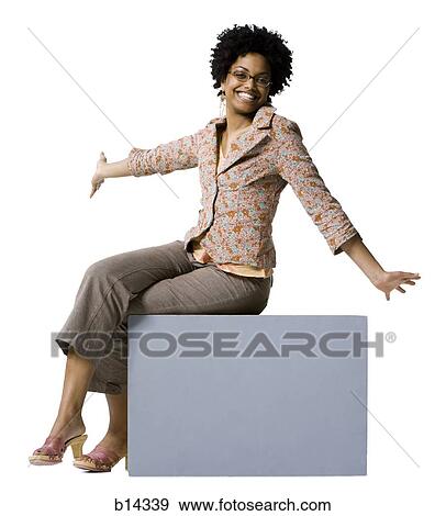 Stock Photo - Woman with eyeglasses sitting on blank sign. Fotosearch