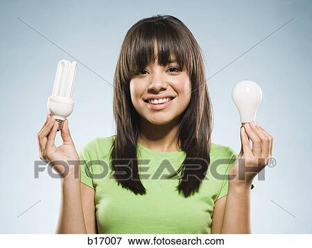 Woman with fluorescent and incandescent light bulbs View Large Photo Image Stock Photo - Woman with fluorescent and incandescent light bulbs. Fotosearch