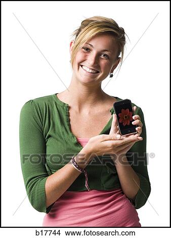 Picture - Woman with handheld electronic device smiling. Fotosearch