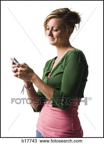 Stock Image - Woman with handheld electronic device smiling. Fotosearch