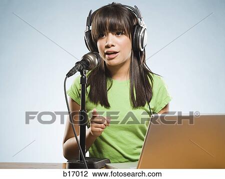 Woman with headphones and laptop singing into microphone View Large Photo Image Stock Image - Woman with headphones and laptop singing into microphone. Fotosearch