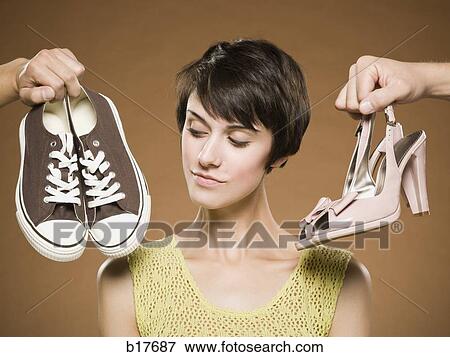 Woman with running shoes and pumps deciding View Large Photo Image Stock Photo - Woman with running shoes and pumps deciding. Fotosearch