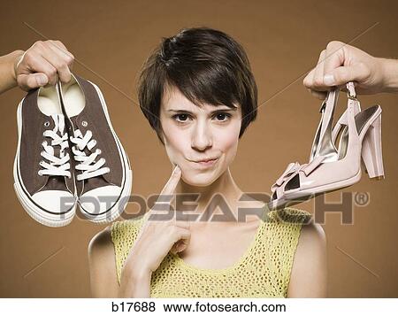 Woman with running shoes and pumps deciding View Large Photo Image Stock Photo - Woman with running shoes and pumps deciding. Fotosearch