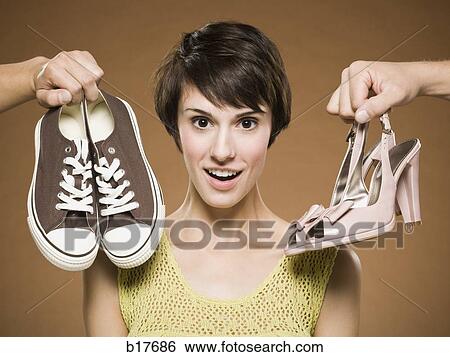 Woman with running shoes and pumps deciding View Large Photo Image Stock Photograph - Woman with running shoes and pumps deciding. Fotosearch