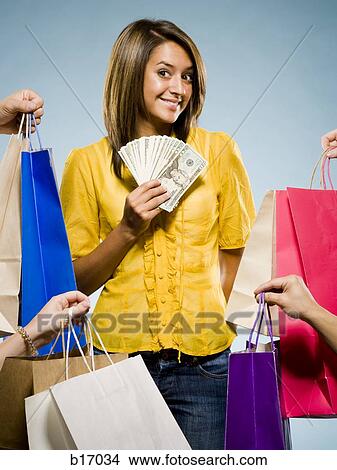 Woman with shopping bags and large sum of cash smiling View Large Photo Image Picture - Woman with shopping bags and large sum of cash smiling. Fotosearch