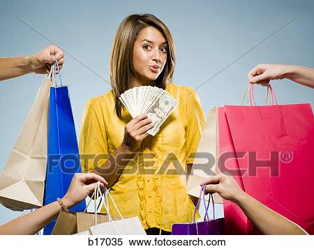 Woman with shopping bags and large sum of cash smiling View Large Photo Image Stock Photography - Woman with shopping bags and large sum of cash smiling. Fotosearch