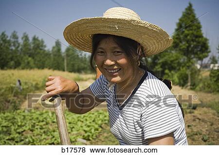 Woman with straw hat working in field outdoors View Large Photo Image Stock Photo - Woman with straw hat working in field outdoors. Fotosearch