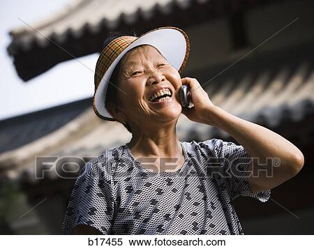 Woman with sun visor outdoors smiling talking on cell phone View Large Photo Image Stock Photography - Woman with sun visor outdoors smiling talking on cell phone. Fotosearch
