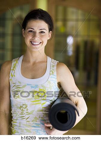 Woman with yoga mat smiling View Large Photo Image Stock Photo - Woman with yoga mat smiling. Fotosearch