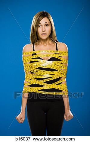 Woman wrapped in measuring tape View Large Photo Image Stock Photo - Woman wrapped in measuring tape. Fotosearch