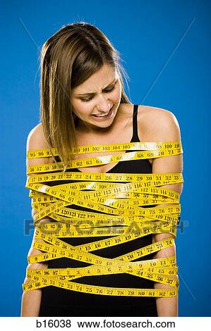 Woman wrapped in measuring tape View Large Photo Image Stock Photo - Woman wrapped in measuring tape. Fotosearch