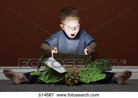 Stock Photo - Young boy opening present. Fotosearch