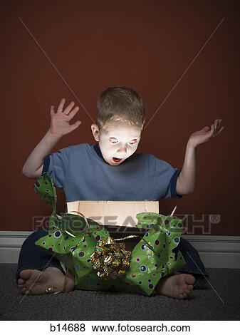 Young boy opening present View Large Photo Image Stock Photo - Young boy opening present. Fotosearch