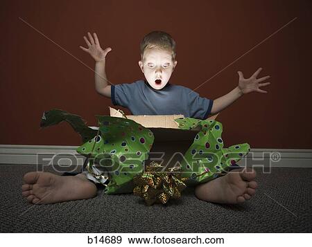 Stock Photo - Young boy opening present. Fotosearch