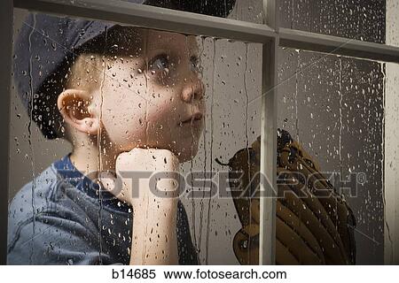 Young boy with baseball glove looking out window on rainy day View Large Photo Image Stock Photography - Young boy with baseball glove looking out window on rainy day. Fotosearch