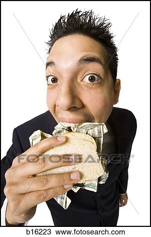 Young businessman eating money sandwich View Large Photo Image Stock Image - Young businessman eating money sandwich. Fotosearch