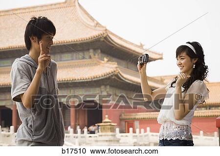 Young couple taking a photograph outdoors smiling View Large Photo Image Stock Image - Young couple taking a photograph outdoors smiling. Fotosearch