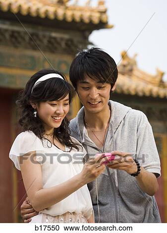 Young couple with mp3 player smiling outdoors View Large Photo Image Stock Image - Young couple with mp3 player smiling outdoors. Fotosearch