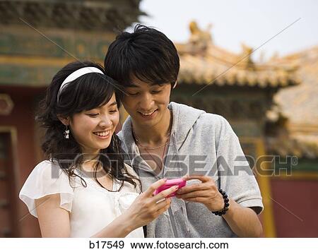 Young couple with mp3 player smiling outdoors View Large Photo Image Stock Photo - Young couple with mp3 player smiling outdoors. Fotosearch