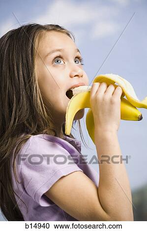 Stock Image - Young girl eating banana. Fotosearch