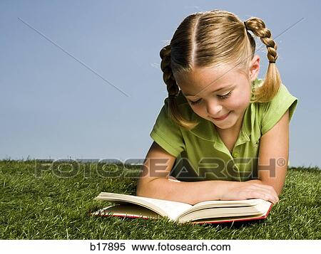 Young girl reading a book on grass. View Large Photo Image Stock Photography - Young girl reading a book on grass.. Fotosearch