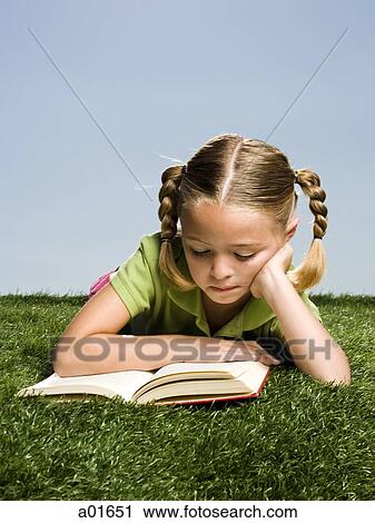Young girl reading a book on the grass. View Large Photo Image Stock Image - Young girl reading a book on the grass.. Fotosearch