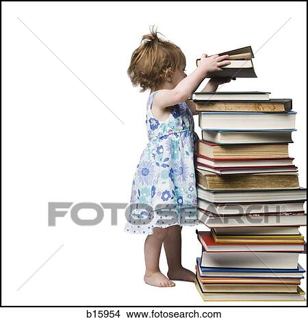 Picture - Young girl standing beside stack of hardcover books. Fotosearch