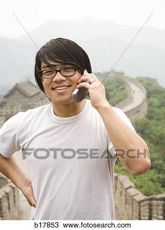 Young man at the Great Wall of China on a mobile phone. View Large Photo Image Stock Image - Young man at the Great Wall of China on a mobile phone.. Fotosearch