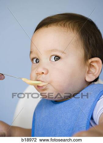 Stock Image - baby boy with a blue bib.. Fotosearch