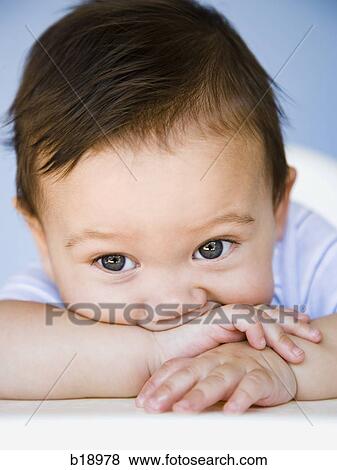 Stock Photo - baby boy with arm in mouth.. Fotosearch