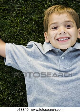 boy lying on the grass. View Large Photo Image Stock Image - boy lying on the grass.. Fotosearch