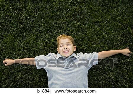 boy lying on the grass. View Large Photo Image Stock Image - boy lying on the grass.. Fotosearch