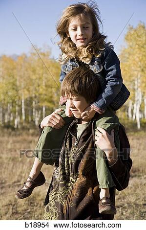 boy with girl on his shoulders. View Large Photo Image Picture - boy with girl on his shoulders.. Fotosearch