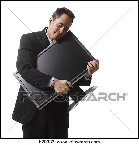 Stock Image - businessman holding a flat screen monitor. Fotosearch