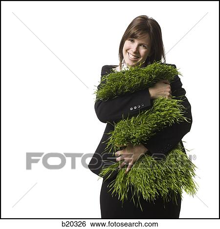 Stock Photograph - businessperson holding a patch of grass. Fotosearch