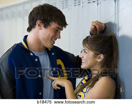 Cheerleader and football player flirting in front of lockers. View Large Photo Image Stock Photography - Cheerleader and football player flirting in front of lockers.. Fotosearch